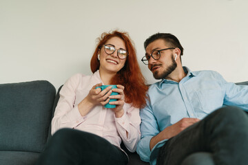 Happy family couple sitting on sofa after hard work day and making a video call