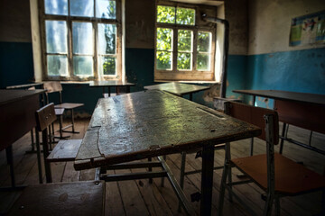 Old and abandoned school classroom interior, in black and white.
