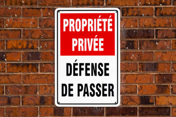 Warning sign on a brick wall (Translation : "private property, no trespassing")