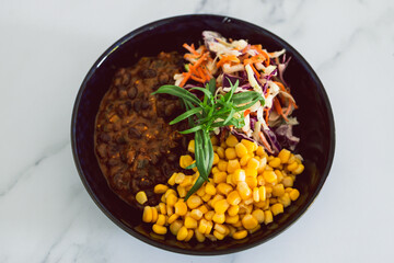 plant-based food, vegan nourish bowl with mexican beans corn avocado and dairy-free coleslaw salad mix