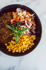 plant-based food, vegan nourish bowl with mexican beans corn avocado and dairy-free coleslaw salad mix