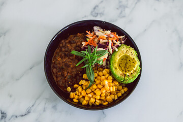 plant-based food, vegan nourish bowl with mexican beans corn avocado and dairy-free coleslaw salad mix