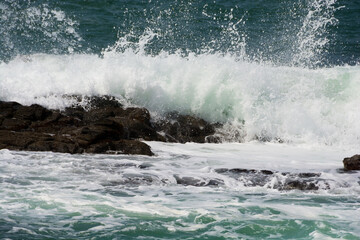 Fototapeta na wymiar 岩に当たって砕ける波 