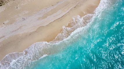 Fotobehang Drone vogelperspectief met witte golven op de prachtige aquablauwe zee en het zandstrand © NinjaTech LLC