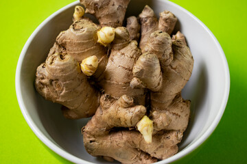 Fresh ginger root on green background