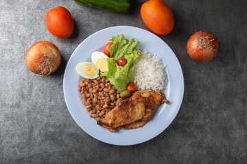 Brazilian food dish with rice beans and chicken top view