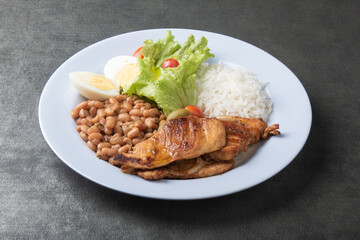 Brazilian food dish with rice beans and chicken