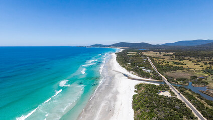 Stunning high angle aerial panoramic drone view of Denison Beach, Denison River and the A3 Tasman Highway just north of the village of Bicheno on the east coast of Tasmania, Australia on a sunny day.