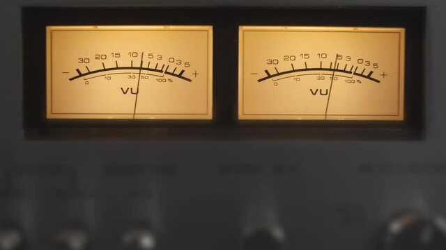 Audio signal levels monitoring audio console on classic sound amplifier. Close-up analog signal indicator with arrow