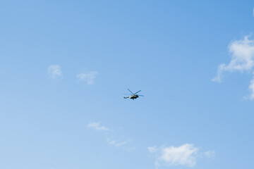 Fototapeta na wymiar helicopter on a background of blue sky with clouds