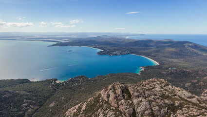 Beautiful high angle panoramic aerial drone view of Coles Bay and Freycinet National park with Richardsons Beach and Coles Bay Village. The famous Hazards mountain range in the foreground.