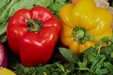 Close up colorful fresh peppers and greens on table