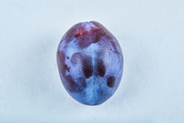 Fresh ripe plum on a blue background