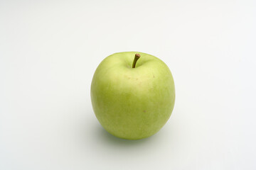 Fresh green apple on a white surface
