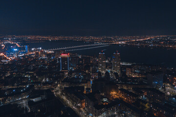 Fototapeta na wymiar Drone view at night, with illuminated streets and dark sky. Beautiful cityscape