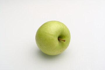 Fresh green apple on a white surface