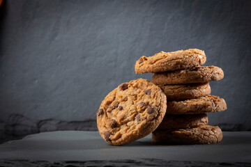 freshly baked Chocolate chip cookies on a dark stone with place for text. Copy space.