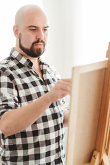 Obraz na płótnie Canvas Creative home leisure. Man does easel drawing