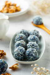 Energy bites made with blue spirulina powder, nuts, dried fruits and coconut flakes. Healthy dessert