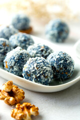 Energy bites made with blue spirulina powder, nuts, dried fruits and coconut flakes. Healthy dessert