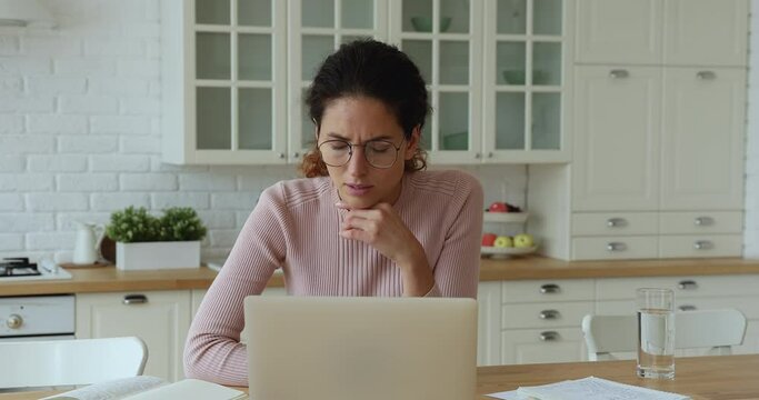Confused young caucasian woman reading email on computer, taking off eyewear, feeling depressed of getting bad news online, professional exam failure, receiving dismissal notice, lost job concept.