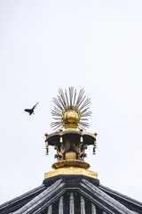 Obraz premium Detail of the golden roof decoration of a buddhist temple wit a crow flying