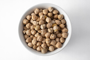 Top view of ceramic pot with uncooked chickpeas. Isolated on white background