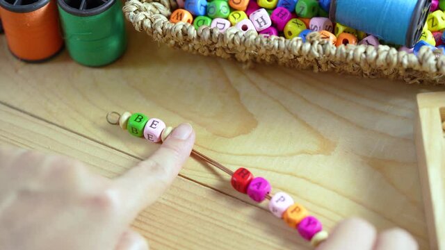 String a bracelet wooden letter beads of be happy word, Close up woman hand string with a colorful Wooden letter beads, mood and tone concept.