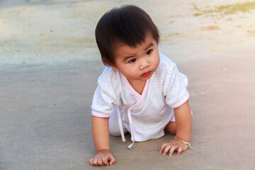 Small baby, little girl creeping, playing on road and sant at beach. Cute baby try to creeping and...