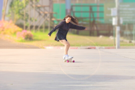 Asian women on skates board outdoors on beautiful summer day. Happy young women play surfskate at park on morning time. Sport activity lifestyle concept - Powered by Adobe