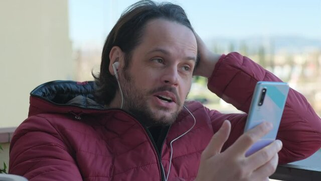 Young man has a video call via smartphone and talks to someone, chatting concept