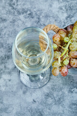 Bunch of grapes and a glass of wine on blue background
