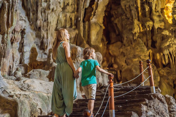 Mom and son tourists in Hang Sung Sot Grotto Cave of Surprises, Halong Bay, Vietnam. Traveling with children concept. Tourism after coronavirus