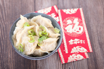 A bowl of dumplings and festival red envelopes
