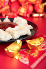 A plate of dumplings and festival red envelopes on the background of festive red