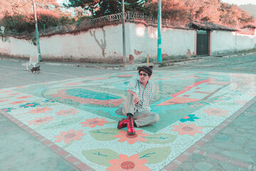 model sitting on colorful street, 70s style dress. colonial town. mosaic
