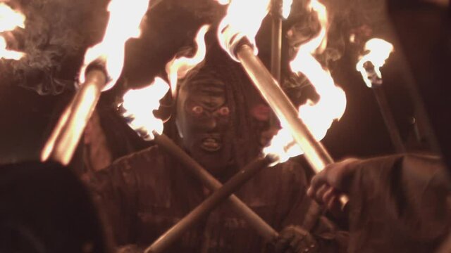 - men in black with torches, procession, rite