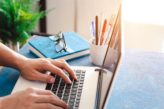 Close Up Shot Of  Male Hands Typing On Laptop While Sitting At Office Desk Indoors, Man Fingers Tapping And Texting On Computer Keyboard While Working In Cabinet, Work Concept.