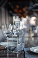 Modern veranda restaurant interior, banquet setting, glasses, plates