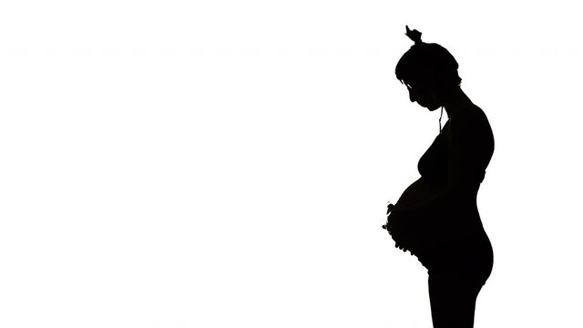 RIGHT SILHOUETTE, A heavily pregnant woman looks down and strokes her belly