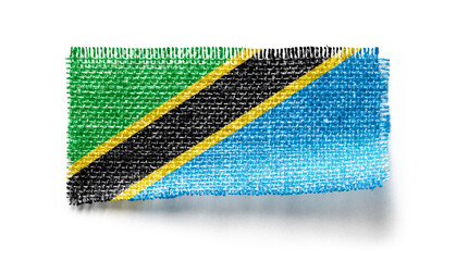 Tanzania flag on a piece of cloth on a white background