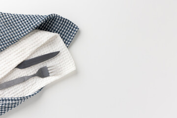 Knives, forks, were placed on a white tableware and napkins.