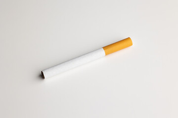 A cigarette is placed on a white table. Take a photo in the studio