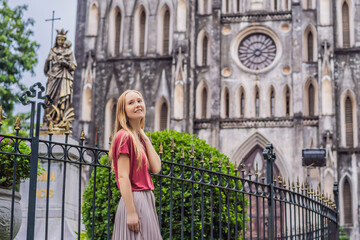 Young woman tourist on background of St Joseph's Cathedral in Hanoi. Vietnam reopens after coronavirus quarantine COVID 19