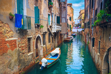 Fototapeta na wymiar Waterfront houses in narrow water canal, Venice, Italy