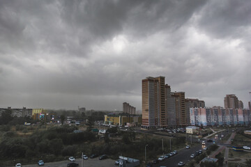 Fototapeta premium City view with modern architecture and a frightening gloomy thunderstorm sky with dark clouds