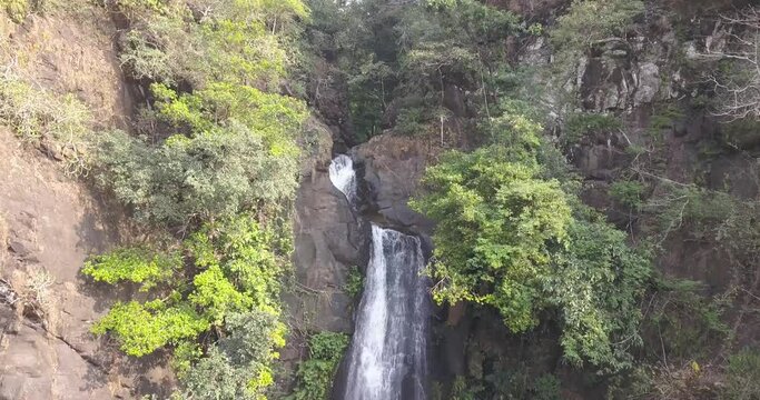 Jungle Cascading Down From Steep Rocky Valley Of Mainapi Waterfall In Netravali Taluka Of South Goa, India. - Aerial Shot