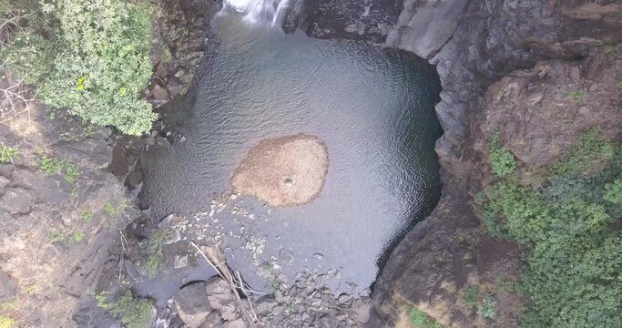 Pristine Lake With Flowing Cascades From Mainapi Waterfall At Netravali Wildlife Sanctuary, South Goa, India. - Aerial Ascending Shot