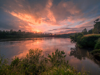 Dramatic Riverside Sunrise with Cloud Reflections