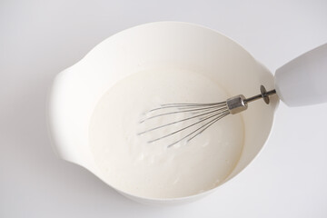 top view of a bowl and a whisk with panna cotta dessert. homemade traditional italian meal. tasty...